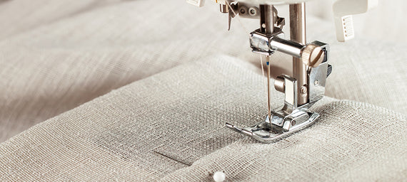 Sewing machine closeup. Needle going through a linen textile.